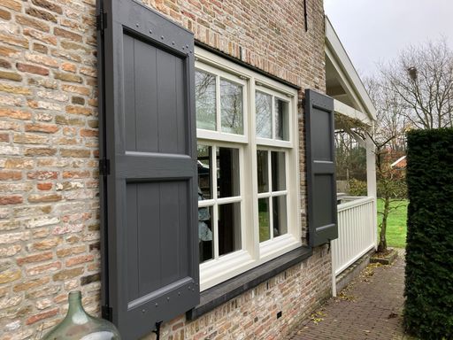 Geplaatst houten kozijn met raamluiken